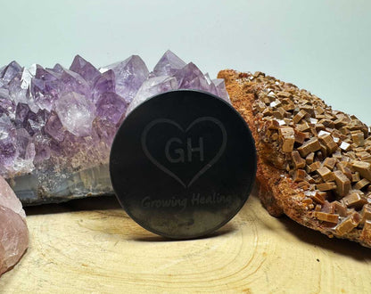 XL Shungite phone tab with Growing Healing logo on wooden surface with crystals