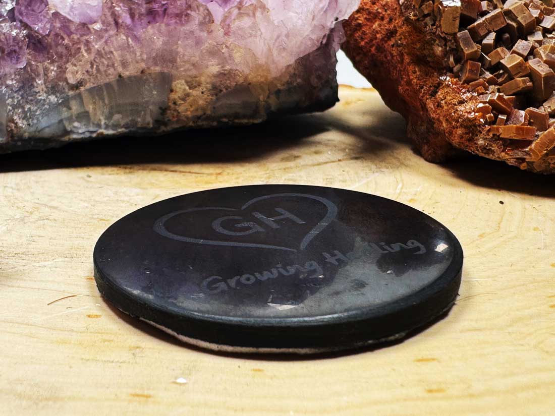 XL Shungite phone tab with Growing Healing logo on wooden surface with crystals