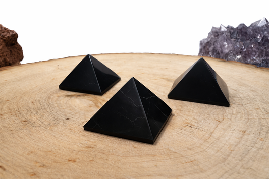 A bundle of three mini carbon-rich Shungite pyramids for tech workspace placement, showcasing a smooth polished finish.