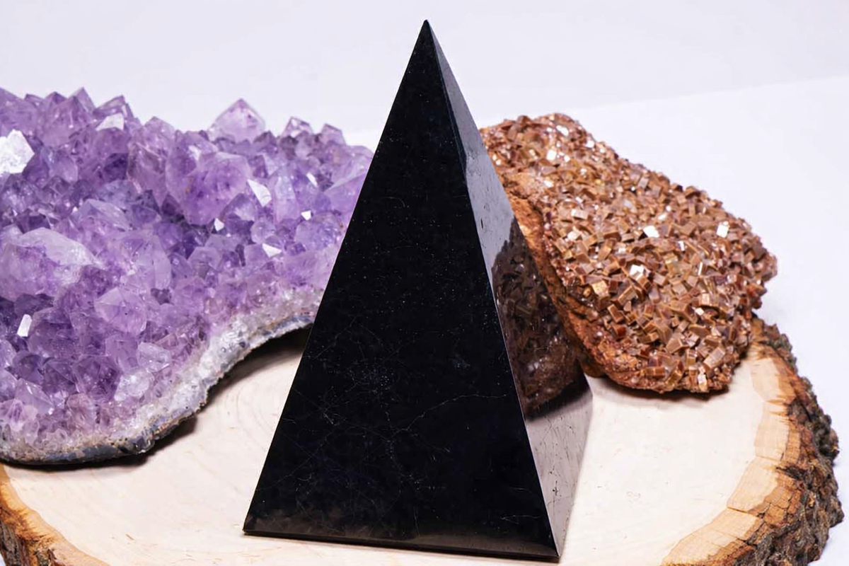 Golod Shungite Pyramid displayed with amethyst and mineral crystals