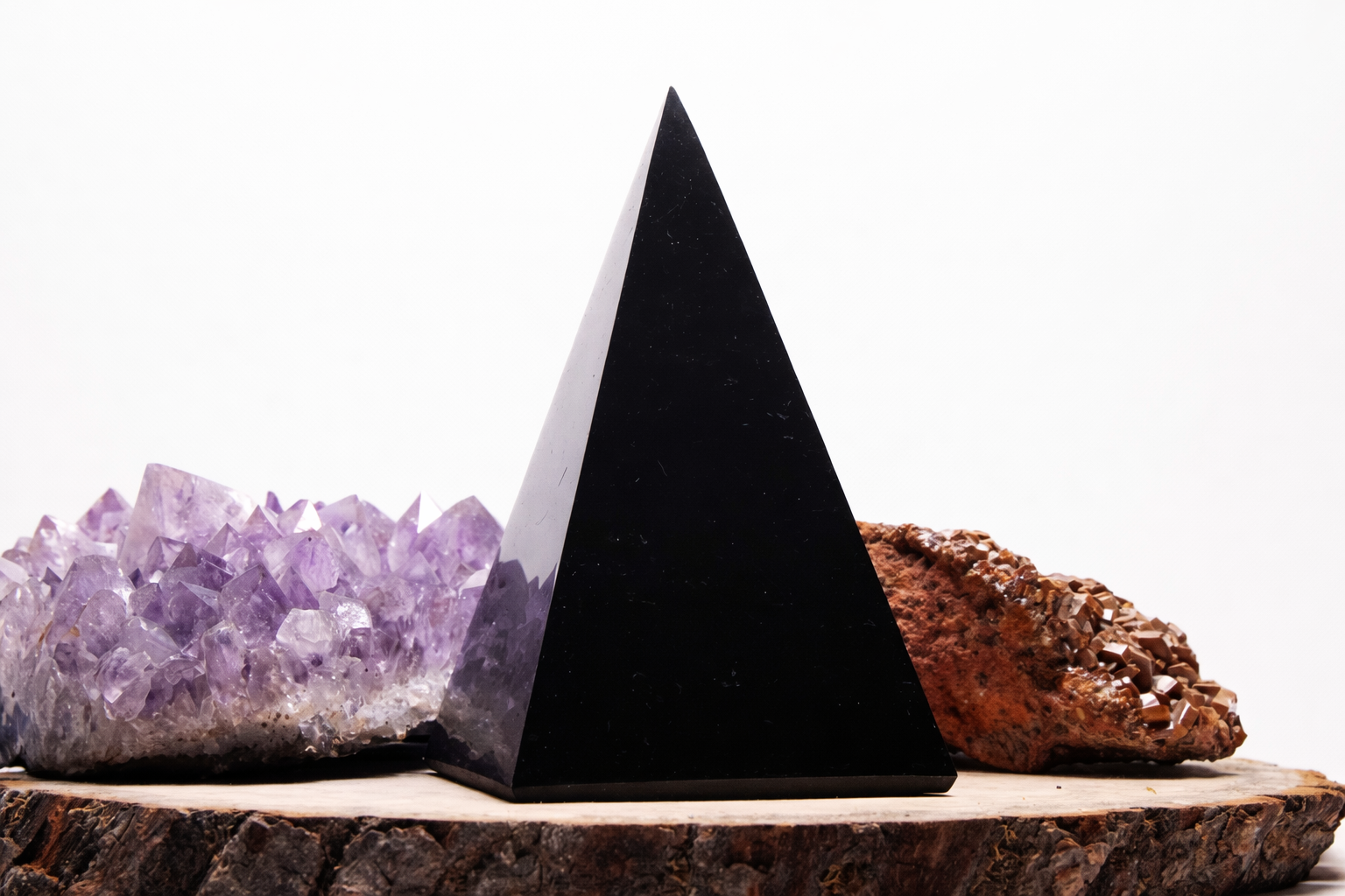 Hand-carved Hi-Pyramid Jr shungite Golod pyramid displayed with amethyst crystal