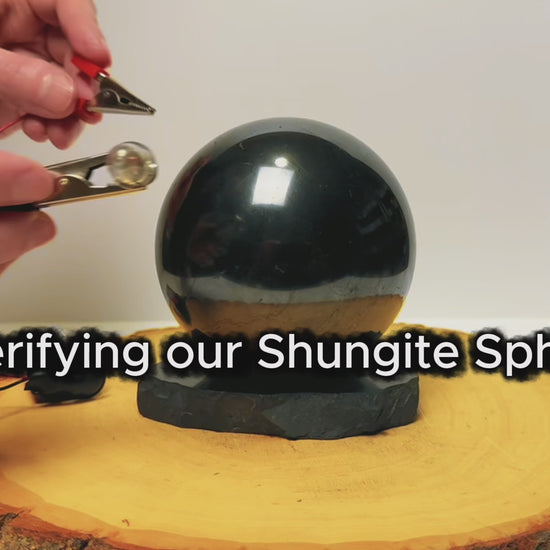 Testing the electrical conductivity of a polished black shungite sphere.