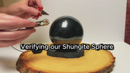 Testing the electrical conductivity of a polished black shungite sphere.